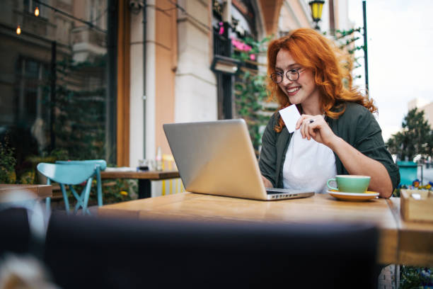 istock Happy young redhead woman relax in cafe  and drinking coffee. She using lap top. 2154559351