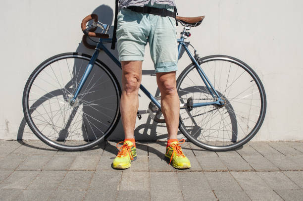 istock Hipsterish wearing man with his  fixed gear bicycle next concrete wall in city 2154563632
