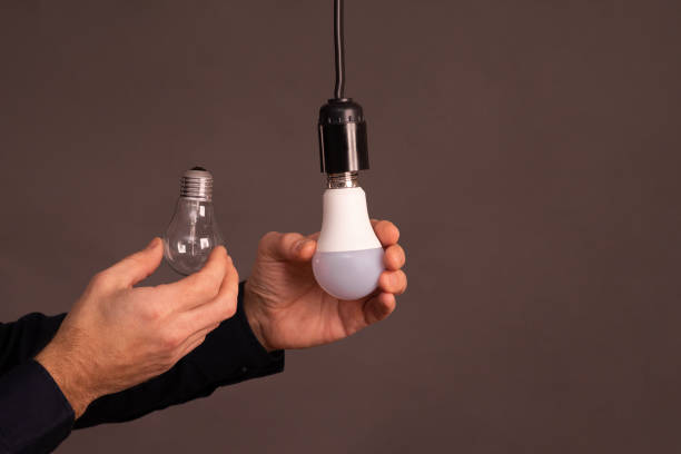 istock incandescent lamp and LED lamp in hand 2154567561