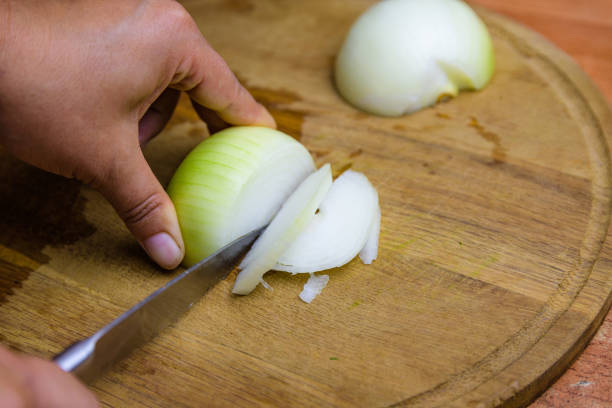 istock Woman cutting white onion on cutting board 2154567878