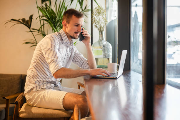 istock Young man working on his laptop while sitting in a cafe 2154568343