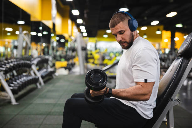 istock Young man lifting heavy weights at the gym 2154569977