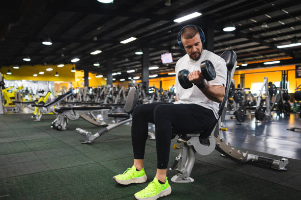 istock Young man lifting heavy weights at the gym 2154569979