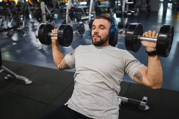 istock Young man lifting heavy weights at the gym 2154570052