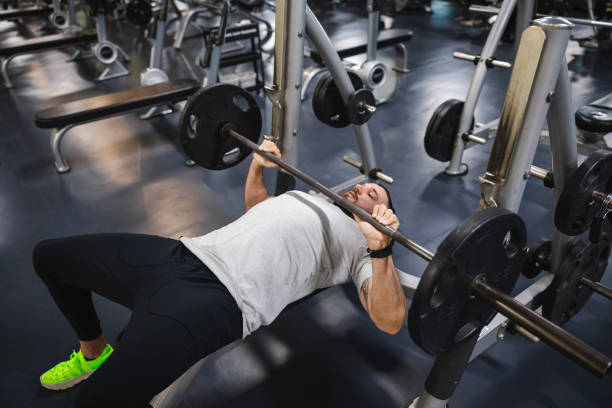 istock Young man lifting heavy weights at the gym 2154570062