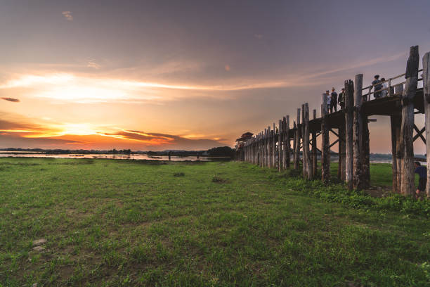 istock Sunset between the pillars supporting the U Bein wooden bridge on the left side. 2154570259