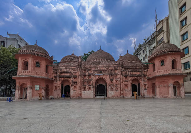 The Sat Gambuj Mosque or Seven Domed Mosque is near the northwestern outskirts of Dhaka in the Mohammadpur area.It is a fine example of the provincial Mughal style of architecture introduced in Bangladesh in the 17th century. The mosque's most notable features are its seven bulbous domes crowning the roof and covering the main prayer hall. The monument stands in a romantic setting on a buttressed 15-foot-high bank overlooking an extensive flood plain.The mosque dates to the reign of Mughal emperor Aurangzeb, and may have been built by the Mughal governor Shaista Khan. la mezquita sat gambuj o mezquita de las siete cúpulas se encuentra cerca de las afueras del noroeste de dhaka, en la zona de mohammadpur. es un buen ejemplo del estilo arquitectónico mogol provincial introducido en bangladesh en el siglo xvii.