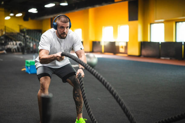 istock Young man working out at the gym by using ropes 2154571016