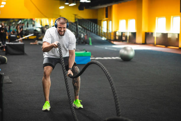 istock Young man working out at the gym by using ropes 2154571026