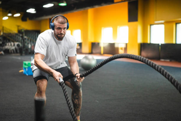 istock Young man working out at the gym by using ropes 2154571032