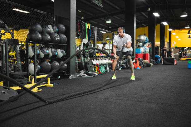 istock Young man working out at the gym by using ropes 2154571062