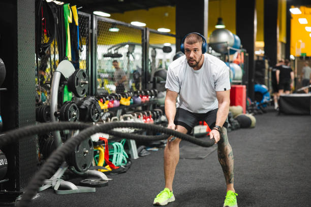 istock Young man working out at the gym by using ropes 2154571065