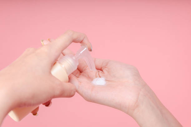 istock Female hands using skincare lotion, cream, emulsion isolated on pink background 2154571792