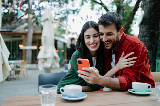 istock Couple laughing and looking at smartphone 2154575666