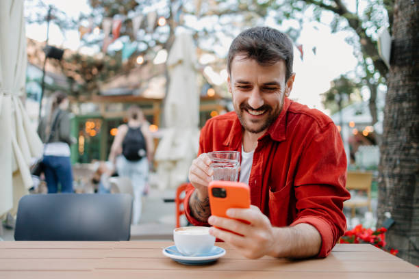 istock Man laughing with phone and coffee cup 2154576014