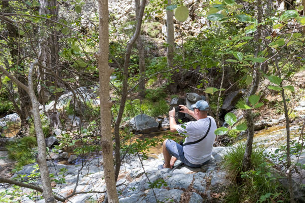 istock Man sitting on mountain river bank 2154576099