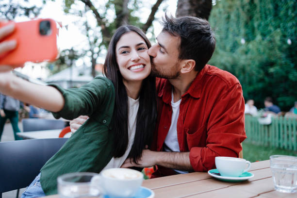 istock Playful couple with smartphone taking a selfie 2154576110
