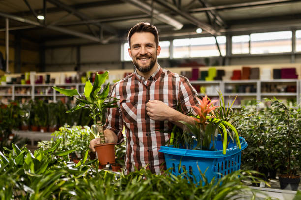 istock Young Man Shopping for Potted Plants 2154580220