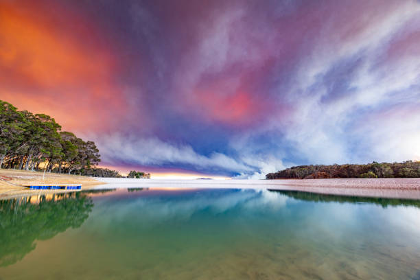 Outback dam reflecting smoke plumes from out of control bush fire. Shot in South Western Australia.