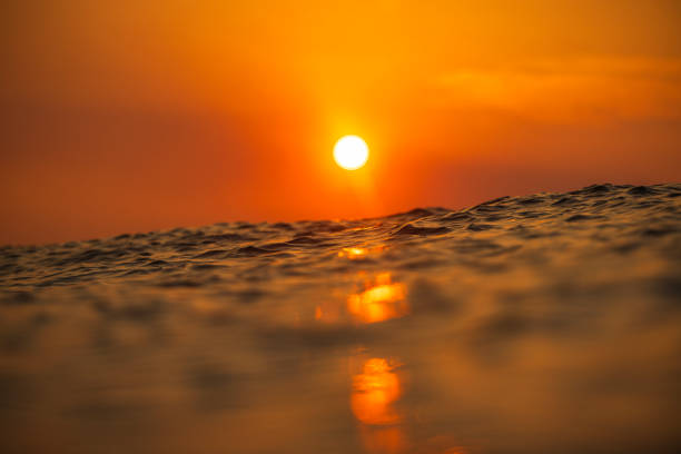 Sun rising over the ocean with dramatic golden light from smoke haze during bush fire. Shot in South Western Australia.