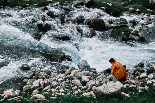 Person is making video of mountain river
