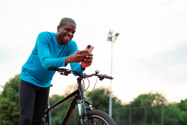 istock Man enjoying outdoor bike ride while using smartphone at park 2154587820