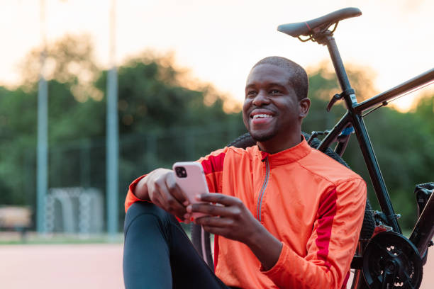 istock Man smiling while checking phone after biking outdoors 2154587839