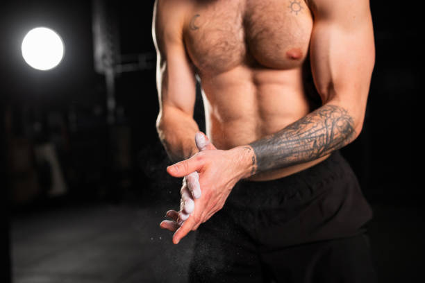 istock Beautiful sport woman preparing for exercise, using chalk on her hands. Routine daily workout for female health. 2154589326