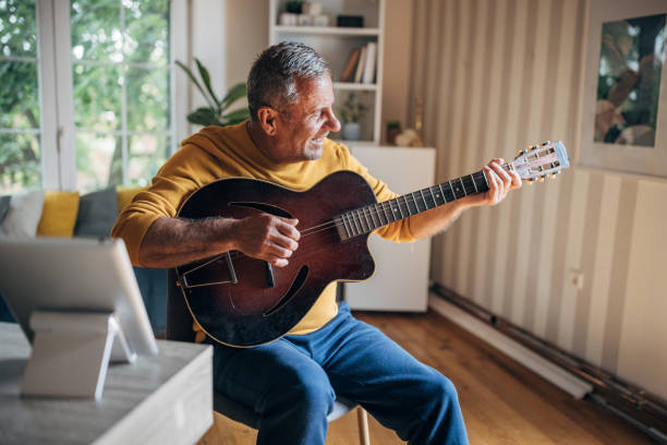 istock Senior man playing guitar at home 2154589681