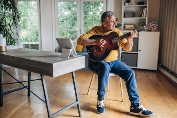 istock Senior man enjoying music hobby at home 2154589697