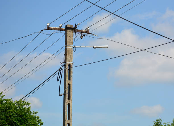 istock Electricity pole with cables and lamp against blue sky 2154591308