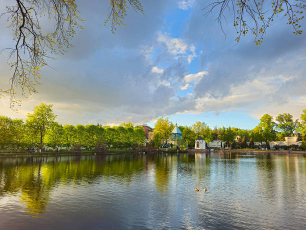 istock Trees reflection on the pond surface, spring park, lake, cloudy sky. 2154596642