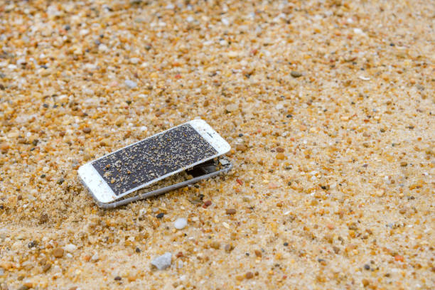lost broken smartphone at sea during vacation lies on the sandy beach. High quality photo
