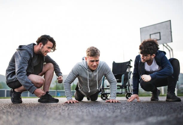 istock Disabled young man exercising with his supportive friends. Male friendship. 2154603944