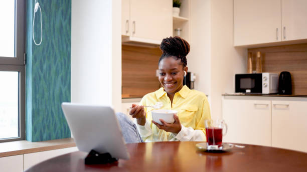 istock Happy woman having a breakfast and watching something online 2154605082