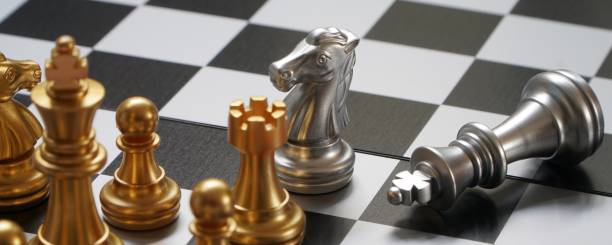 istock A silver knight stands over a fallen silver king in a chess game. 2154607623