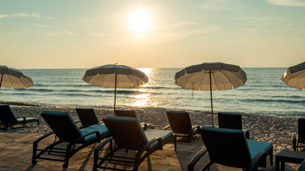 istock Sunset beach scene with empty lounge chairs and umbrellas facing ocean, capturing serene evening atmosphere 2154608238