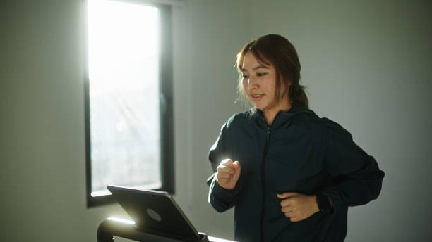 istock Asian woman jogging on treadmill. 2154608694