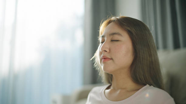 istock Asian woman meditating on mat at home. 2154608696