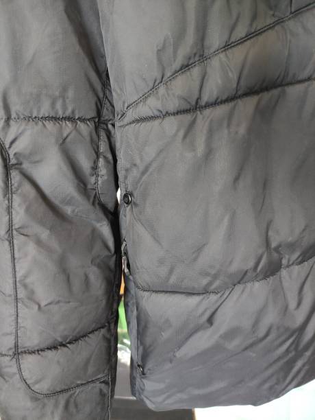 istock Dark winter jacket hanging on a hanger on closet door 2154610898