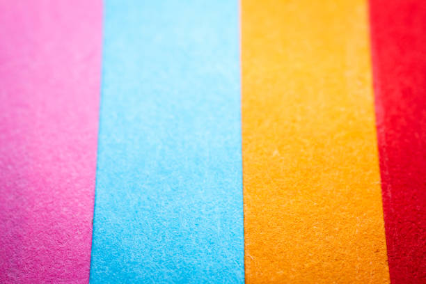 Extreme macro of multicolor background from different colors papers. Abstract colorful vibrant paper textures. Selective focus, shallow depth of field.