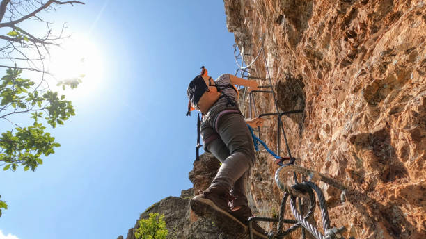 istock Young woman climbs cliff on via ferrata 2154614552