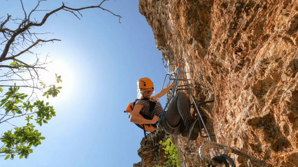 istock Young woman climbs cliff on via ferrata 2154614589