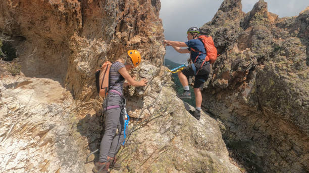 istock Climbers ascend cliff on via ferrata 2154614644