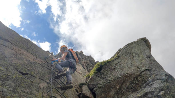 istock Young woman climbs cliff on via ferrata 2154614911