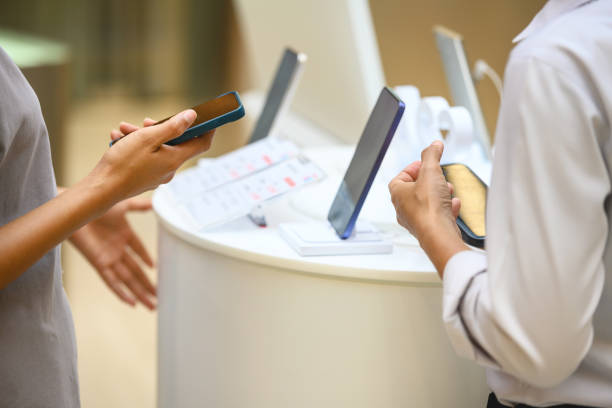 The saleswoman helps the customer choose a smartphone, shows him the possibilities and advantages