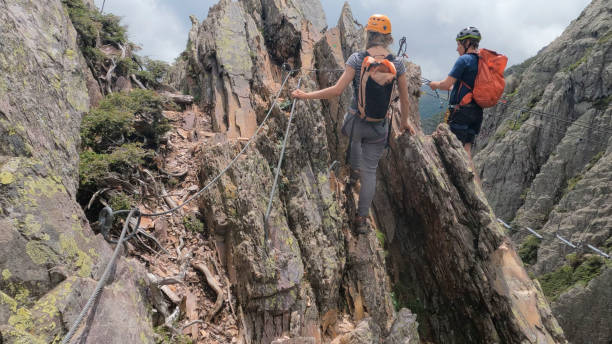 istock Climbers ascend cliff on via ferrata 2154615470