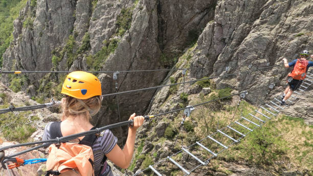istock Climbers cross ladder on via ferrata 2154615485