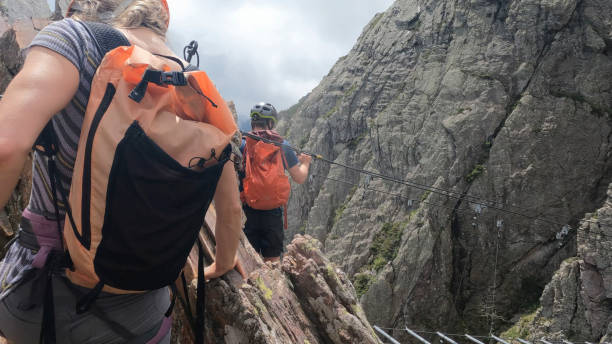 istock Climbers ascend cliff on via ferrata 2154615487