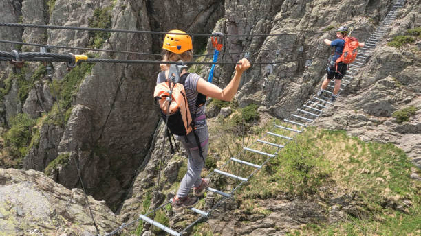 istock Climbers cross ladder on via ferrata 2154615506